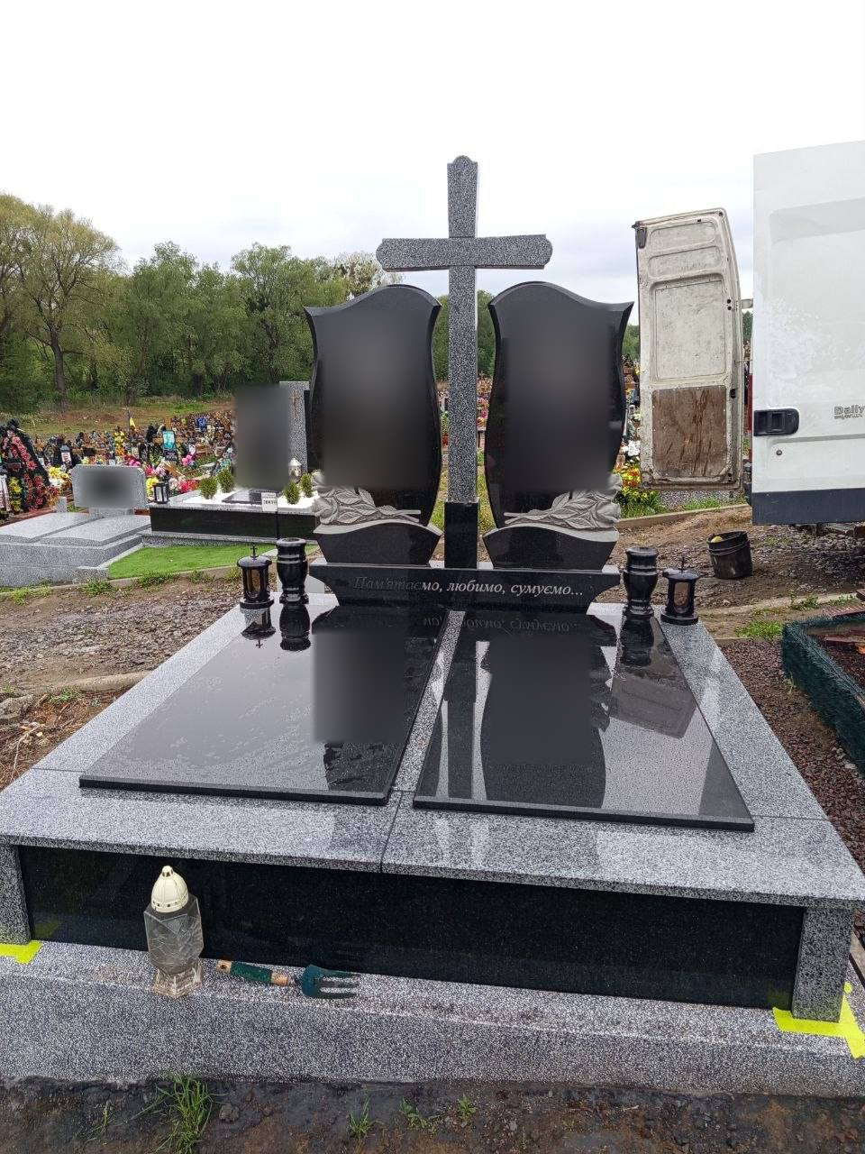 Подвійний пам’ятник із сірим хрестом і двома суцільними чорними полірованими плитами